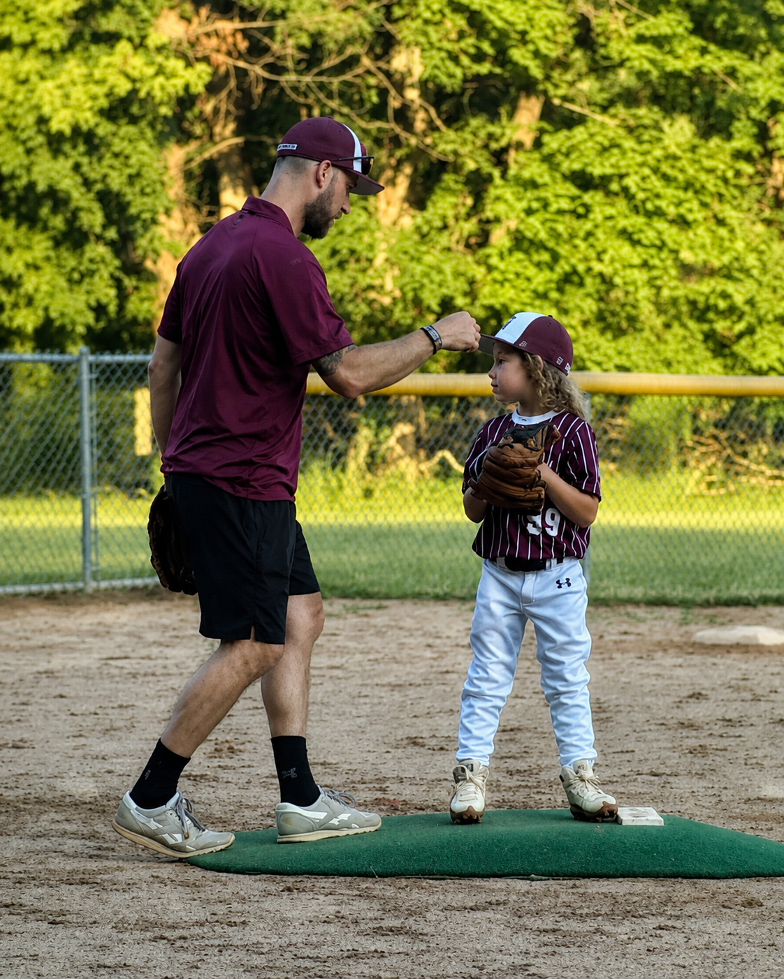 Jake coaching his son on the pitching mound